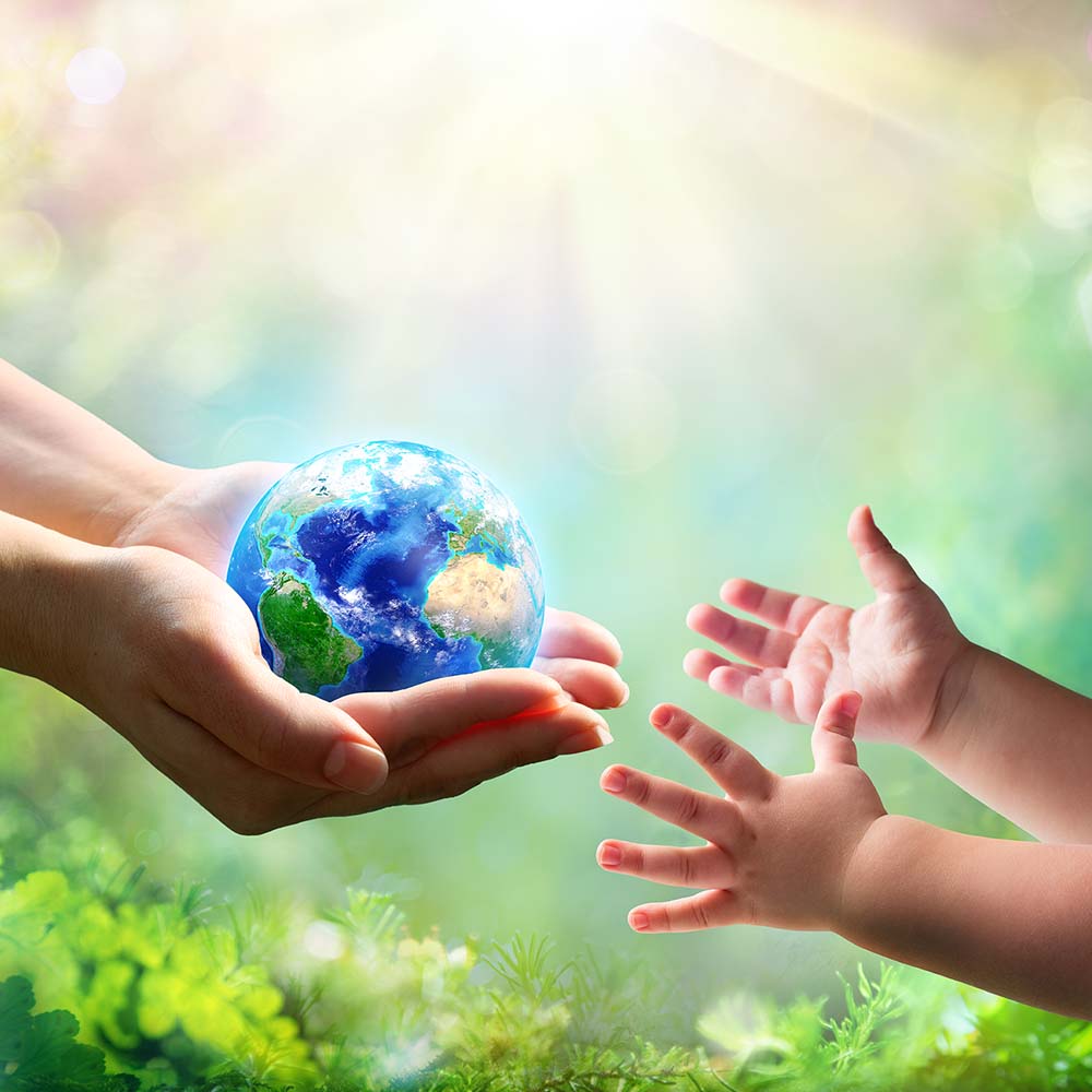adult woman's hands handing a earth globe to child hands