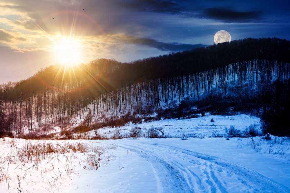 Image of SunSet and MoonRise over a snowy winter hill, trees, and field.