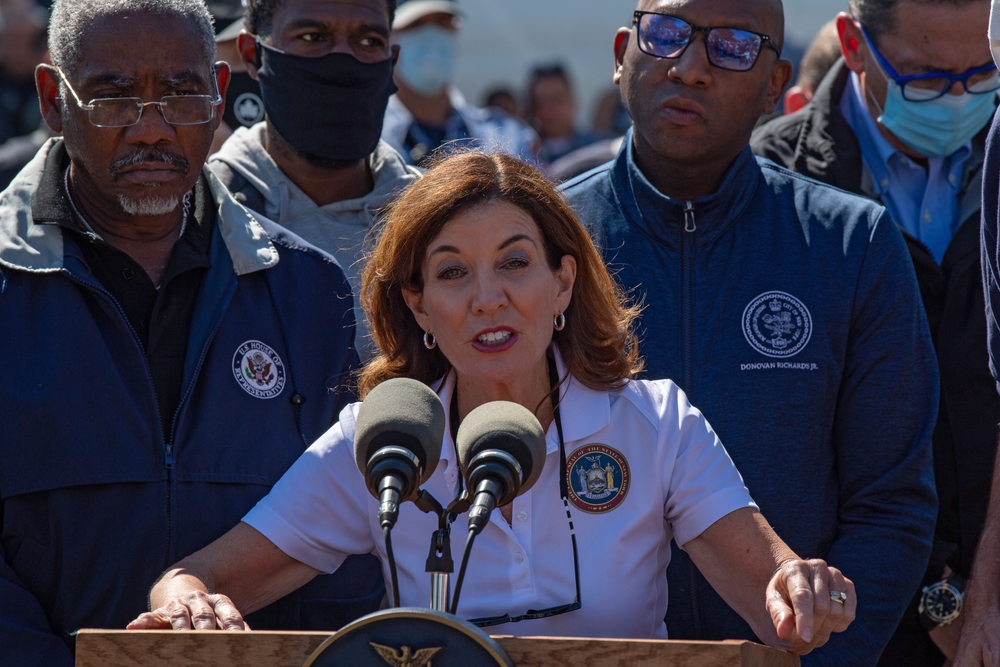 NY State Governor Kathy Hochul at podium before microphones, to keep climate hope alive.
